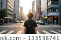 Person Stands at Crosswalk During Sunset in Urban Cityscape with Traffic Lights 133538741