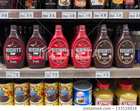 Variety of Hershey's syrup bottles displayed on supermarket shelf Variety of Hershey's syrup bottles displayed on supermarket shelf 133538918