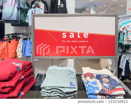 Sale on apparel featuring promotional display in retail store for summer clothing Sale on apparel featuring promotional display in retail store for summer clothing 133538921