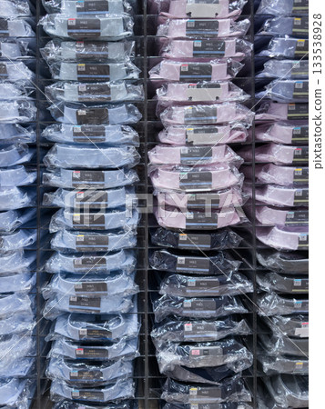 Layered display of folded shirts in various colors arranged in a retail setting Layered display of folded shirts in various colors arranged in a retail setting 133538928