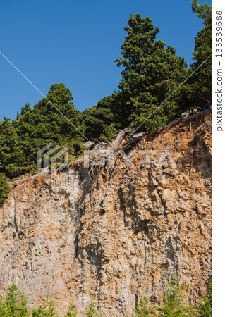 Cretan mountain landscape with exposed roots of old pine tree after landslide. Cretan mountain landscape with exposed roots of old pine tree after landslide. 133539688