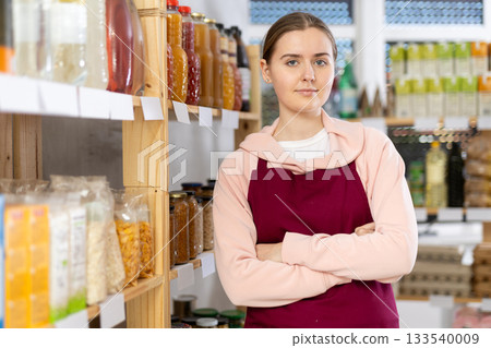Portrait of female seller in an apron behind the counter of grocery store 133540009
