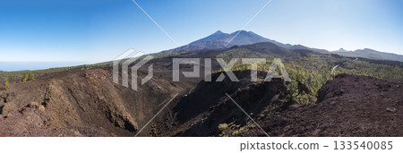 Wide panoramic view on volcano Pico del Teide with snow spots from hiking trail Samara. Mountains and lava fields with pine tree forest. El Teide National Park, Tenerife, Canary Islands, Spain 133540085
