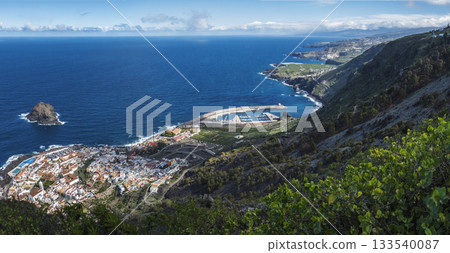 Panorama of Garachico from Mirador de Garachico. Colorful houses and harbor. Ocean with lava rock pools and island. Popular tourist destination, Tenerife Canary Islands. Aerial wide postcard 133540087