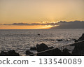 Orange sunset at sea shore promenade in Playa de San Juan, Tenerife, Spain in the south of Tenerife with ocean waves crushing black lava rocks 133540089