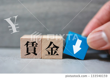 Image of a wage decline. Wooden blocks and arrows indicating a decrease in income. Image of a wage decline. Wooden blocks and arrows indicating a decrease in income. 133540159