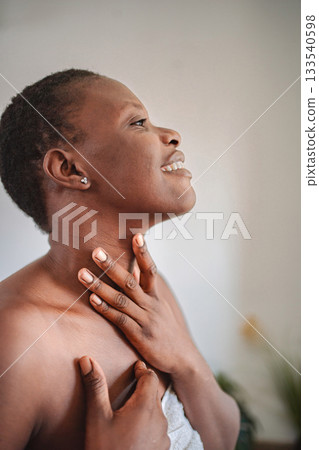 Young woman applying moisturizer on her neck after shower 133540598
