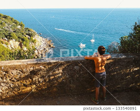 Child Enjoying Coastal View with Boats in Distance Child Enjoying Coastal View with Boats in Distance 133540891