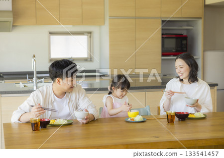 一家人其樂融融地圍坐在餐桌旁 133541457