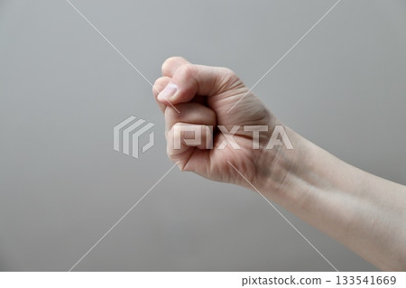 A woman's right hand about to strike with a parrot - Image of violence 133541669