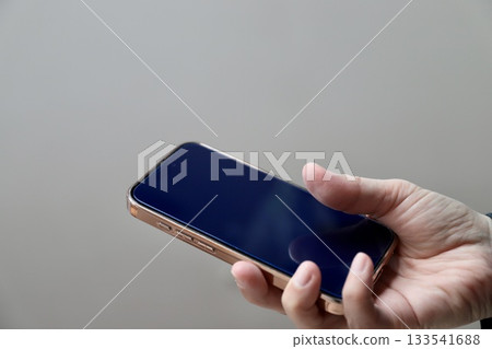 一位中年婦女右手拿著智慧型手機 133541688