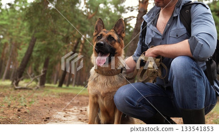 Trekking through the woods, Man and dog relaxing, German Shepherd with owner in forest, Nature escape for two, Best friends outdoors, Bonding in fresh air, Dog owner adventure, Leisure time in the 133541853