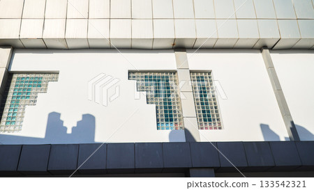 Wall of a building with glass cube windows in bright sunlight Wall of a building with glass cube windows in bright sunlight 133542321