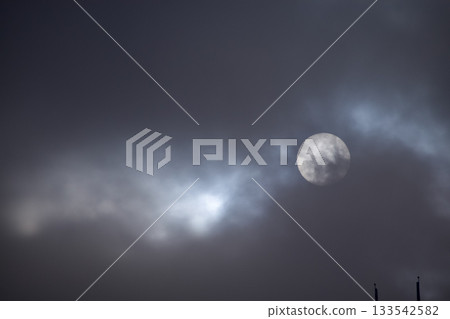 Full moon with dramatic cloudscape. Cloudy overcast sky with moon. Nature scene. 133542582