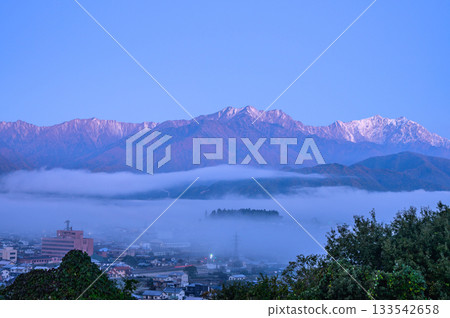 黎明時分，大町的城市景觀籠罩在薄霧之中，立山山脈隱約可見。 133542658