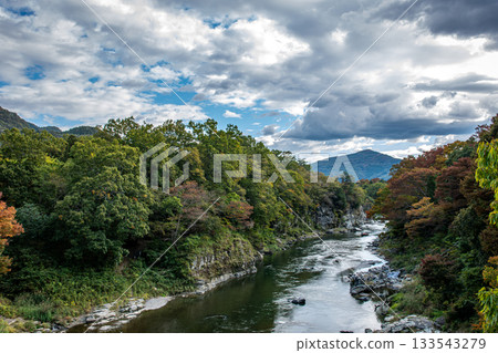 Arakawa River in Nagatoro Valley, mountains with autumn leaves beginning to change color, and a dramatic autumn sky Arakawa River in Nagatoro Valley, mountains with autumn leaves beginning to change color, and a dramatic autumn sky 133543279