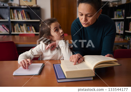 Teacher And Student Reading Together In Library, Learning Focus And Support Teacher And Student Reading Together In Library, Learning Focus And Support 133544177