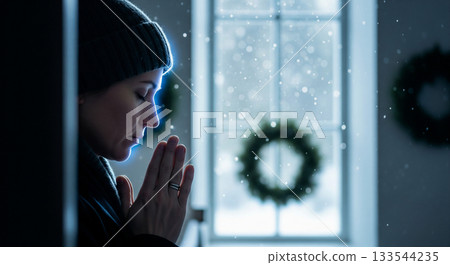 In a minimalist Scandinavian church, a person prays silently, hands clasped in front of their chest. Blue moonlight filters through a window, enhancing the tranquil atmosphere. 133544235