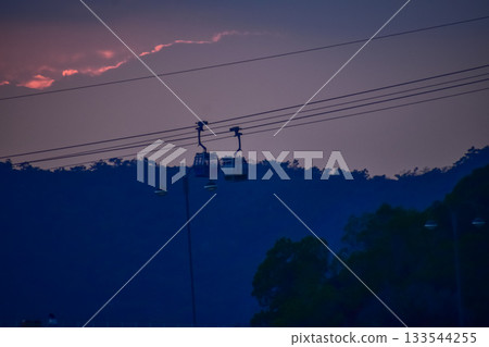 The scene of Cable Car in Hong Kong under the sunset from the view of Tung Chung, Hong Kong. It is one of transportations to the tourist attractions located at Ngong Ping, Lantau Island, in Hong Kong. 133544255