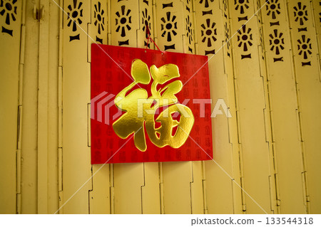 A chinese traditional calendar hanging on the iron door gate. Traditional practice to hang a big red calendar on the door for decoration. Translation: Luck. A chinese traditional calendar hanging on the iron door gate. Traditional practice to hang a big red calendar on the door for decoration. Translation: Luck. 133544318