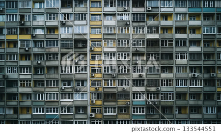The geometric pattern facade of a densely packed apartment building creates a monotonous urban texture. The geometric pattern facade of a densely packed apartment building creates a monotonous urban texture. 133544551