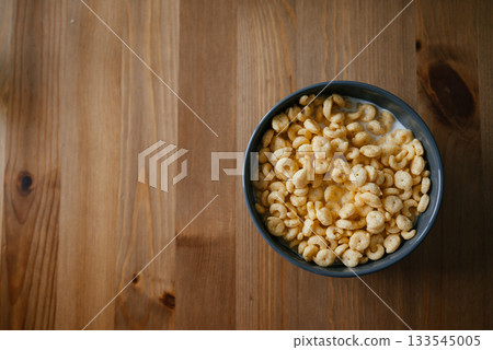 Bowl of Milk and Cereal on Wooden Table 133545005