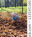 Joyful child in golden autumn leaves. 133545160