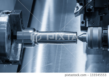 The operation CNC lathe machine finish cut the metal shaft parts in the light blue scene. 133545553