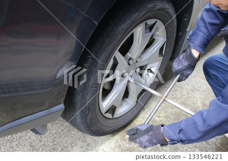 Changing tires with a cross wrench 133546221