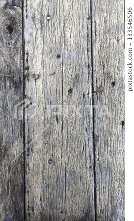 Weathered wooden plank texture with rustic gray tones and nail holes evoking age and character 133546506