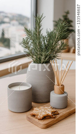 Soft candlelight shines beside a plate of cookies and greenery, with warm hues from autumn leaves visible through the window 133546687