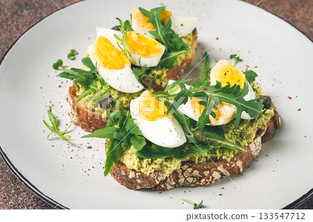 sandwich with mashed avocado, boiled egg, and arugula, on bread , homemade, breakfast, sandwich with mashed avocado, boiled egg, and arugula, on bread , homemade, breakfast, 133547712