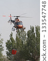 Helicopter in Action Carrying Water Bucket for Firefighting 133547748