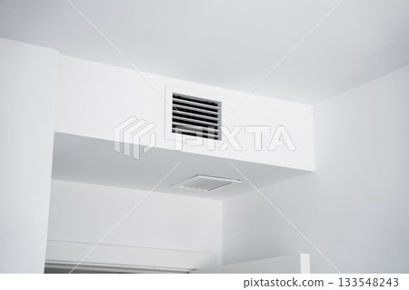 Ceiling ventilation grille in white modern interior providing clean airflow and functional architectural detail 133548243