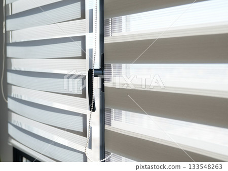 Modern striped window blinds with soft daylight filtering through fabric layers Modern striped window blinds with soft daylight filtering through fabric layers 133548263