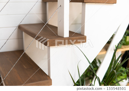 Wooden staircase with white sides and brown steps in bright minimalist home interior Wooden staircase with white sides and brown steps in bright minimalist home interior 133548501