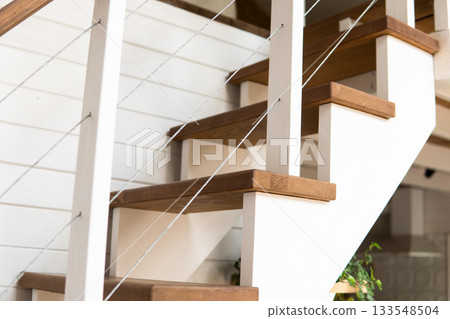Minimal close up of wooden staircase with white railing in cozy modern home 133548504