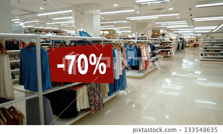 A rack holds several white shirts with a sign advertising a 70% discount off the original price 133548635