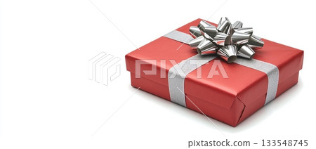 A beautifully wrapped red gift box with a shiny silver ribbon sits on a light background, perfect for any festive event 133548745