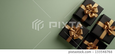 Two beautifully wrapped black gift boxes with golden ribbons sit on a rich dark green background, ideal for festive moments and surprises 133548768