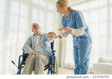 Support rehabilitation healthcare. Nurse helps old man patient in wheelchair picking up dumbbells. Paralyzed man in chair for people with disability doing sports exercise with nurse. Medical caregiver 133548797