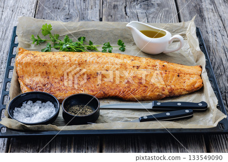 roasted whole salmon fillet on baking sheet 133549090