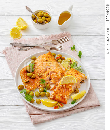 roasted salmon fillet on plate with green olives roasted salmon fillet on plate with green olives 133549096