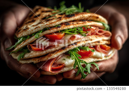 Savory Piadina Romagnola stacked with melting mozzarella and fresh ingredients 133549280