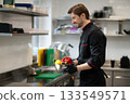 Man cook holding plate of colorful veggies in kitchen 133549571