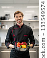 Cook standing and holding dish with pepper cucumber and tomato 133549574