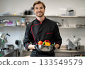 Professional chef holding plate with fresh vegetables 133549579