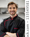 Chef standing with crossed arms in kitchen 133549581
