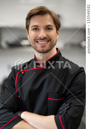 Chef standing with crossed arms in kitchen 133549581