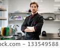Chef standing with crossed arms in kitchen 133549588
